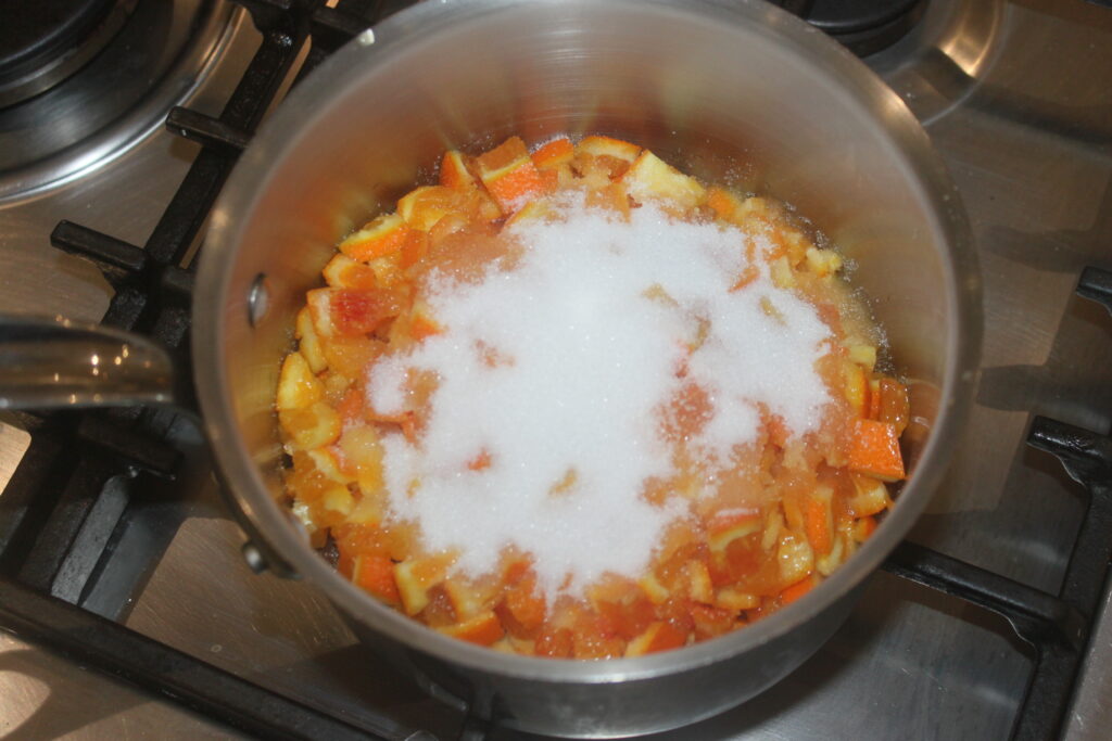 Une casserole sur le feu avec des fruits en dés et du sucre créera une garniture succulente semblable aux tartelettes à la crème d'orange.